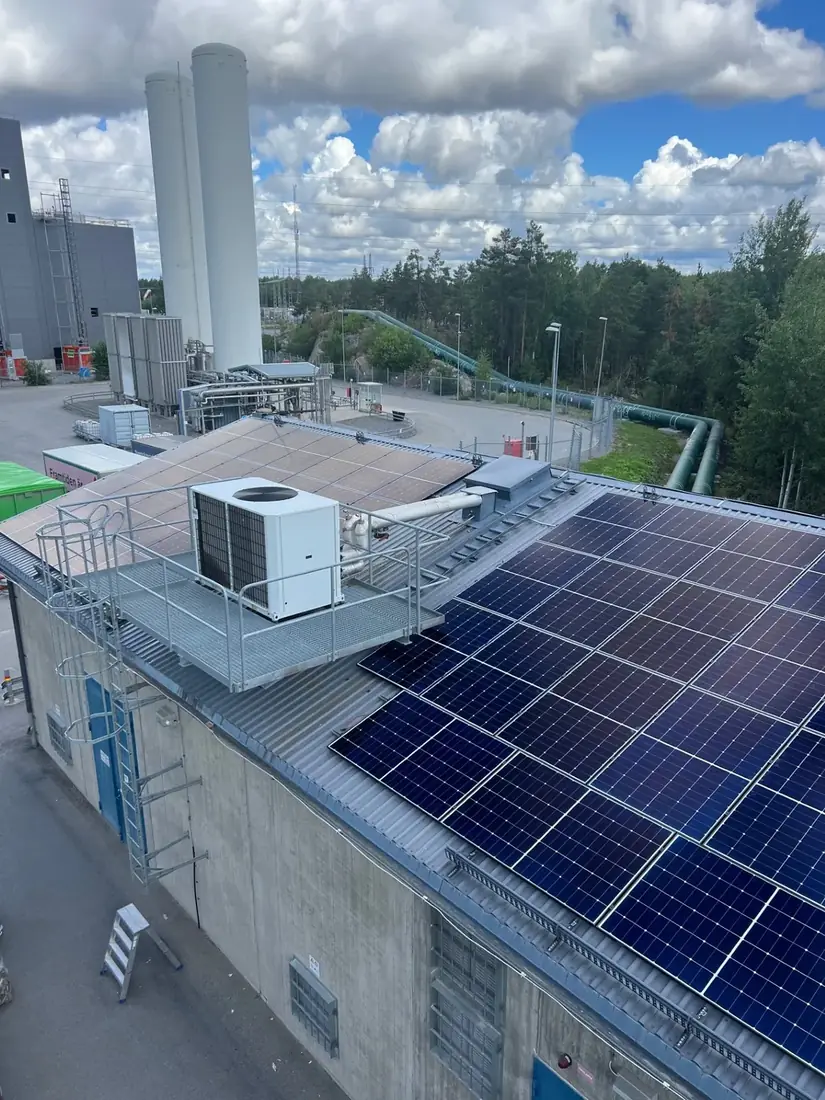 Översiktsbild över ett platt industritak täckt av solpaneler med ventilationsaggregat mellan raderna.