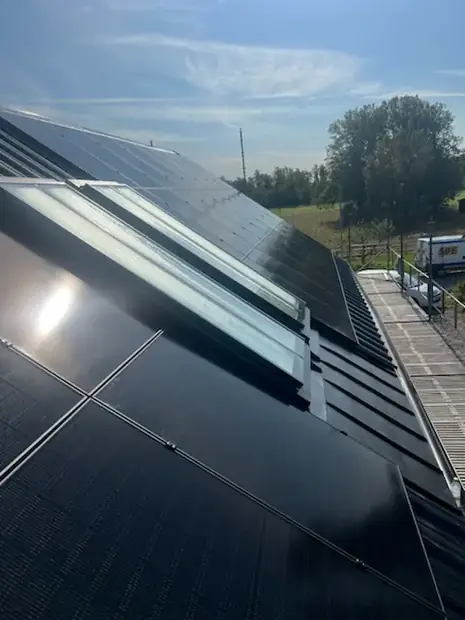 Solpaneler monterade runt ett takfönster på ett villatak.